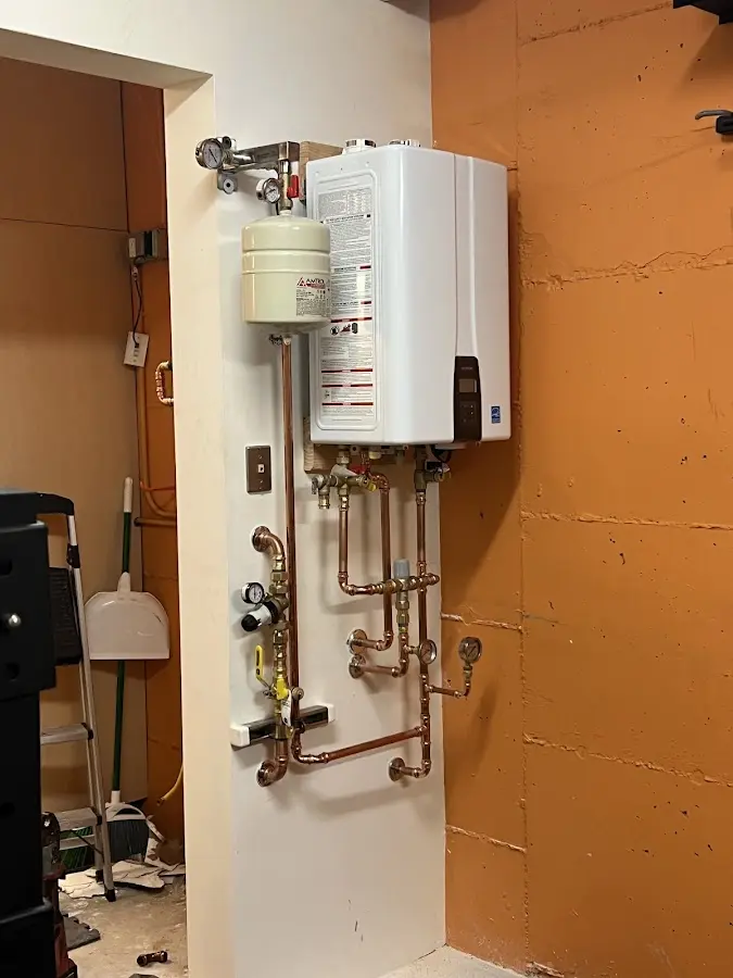 Plumbing technician inspecting water heater connections in Jensen Beach